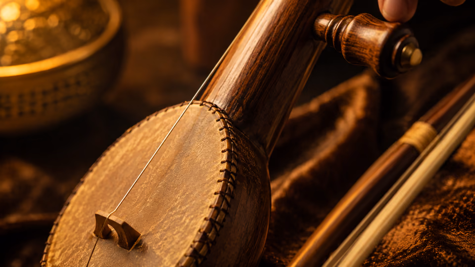 Close-up of a traditional wooden string instrument in warm amber light